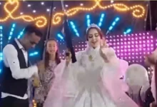 عروس تحمل سلاحاً آلياً فوق الكوشة خلال حفل زفاف في قنا