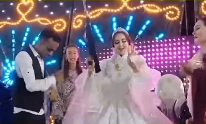 عروس تحمل سلاحاً آلياً فوق الكوشة خلال حفل زفاف في قنا